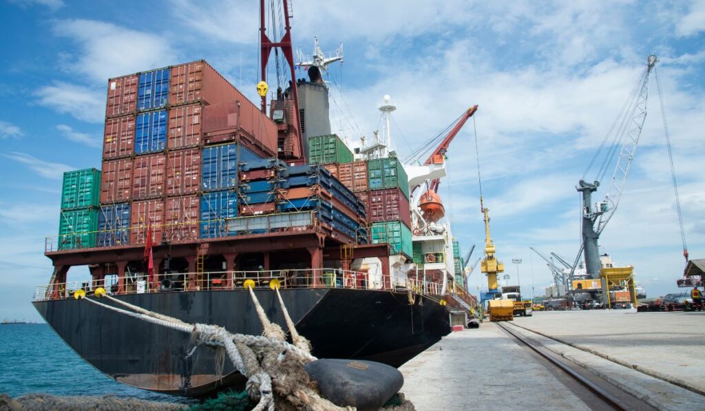 Barco portacontenedores cargado en un muelle con grúas.