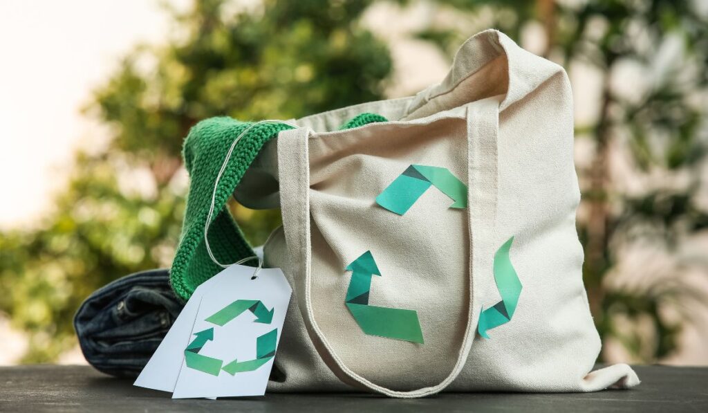 Bolsa de tela reutilizable decorada con símbolos de reciclaje.