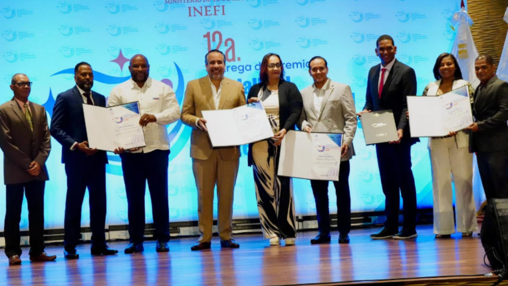Un grupo de personas recibiendo certificados en un escenario.