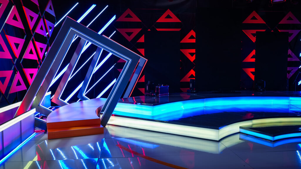 Escenario moderno con luces de neón y triángulos rojos.