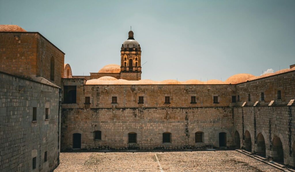 Edificio histórico con cúpulas y torre de campanario bajo cielo despejado.