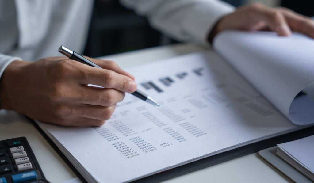 Persona revisando documentos financieros con calculadora