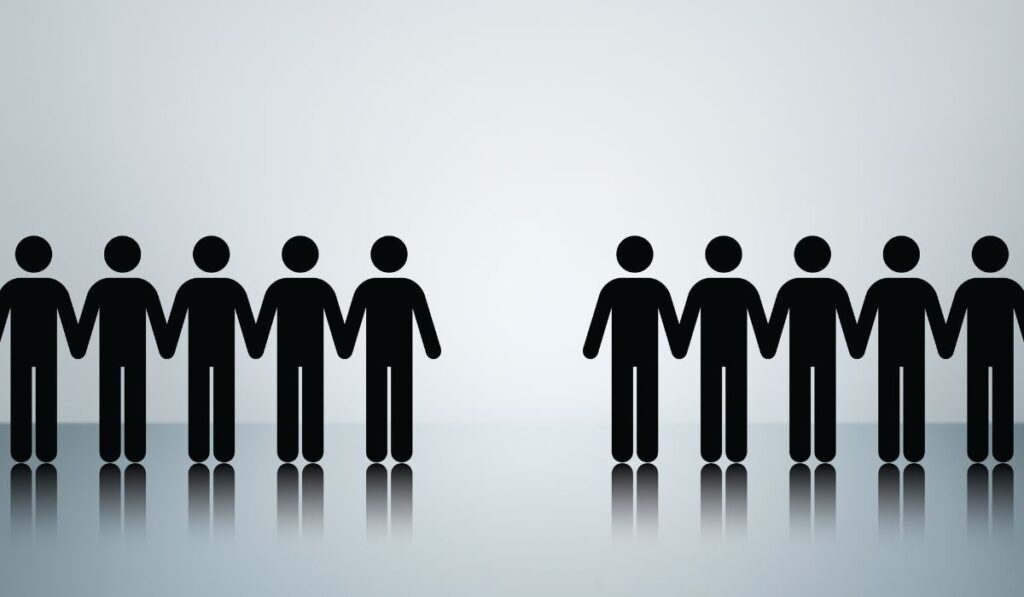 Grupos de personas tomadas de la mano, divididas por un espacio.