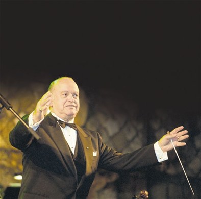 Director de orquesta con batuta dirige en un concierto.