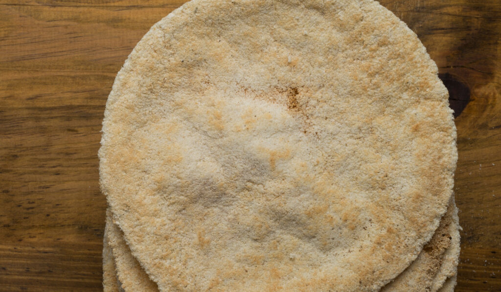 Tortilla de tapioca apilada sobre una superficie de madera.