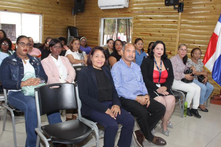 Grupo de personas sentadas en una sala de reuniones.