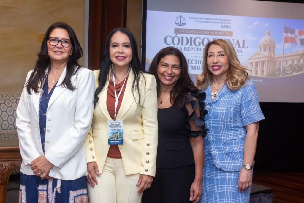 Cuatro mujeres posan frente a una pantalla en un congreso.
